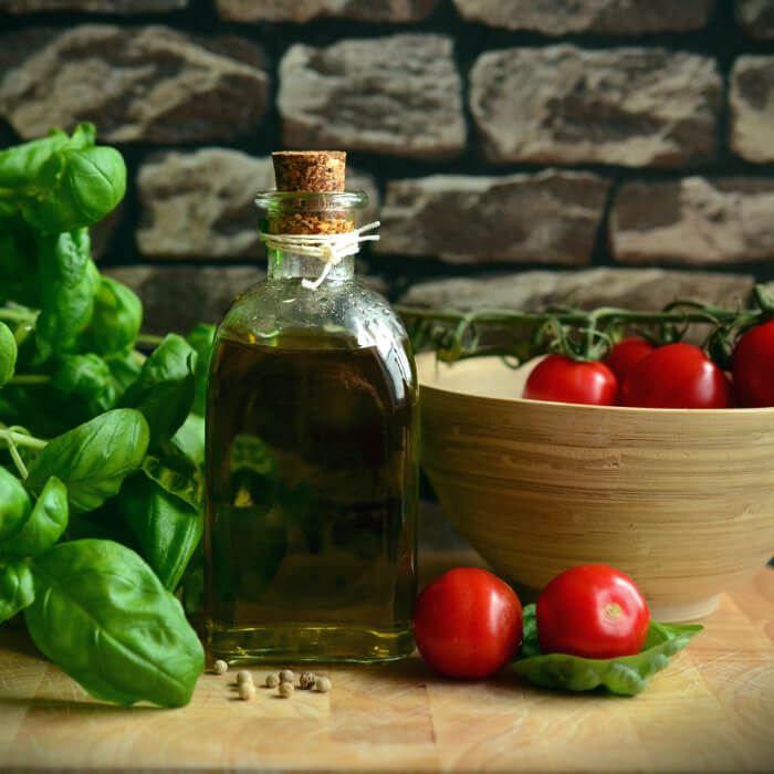 Bottle of olive oil with tomatoes on a vine