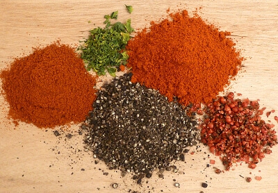 The spices for all purpose seasoning in little piles on a cutting board