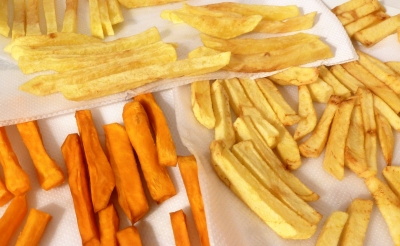 French fries draining on a paper towel after first being fried in oil