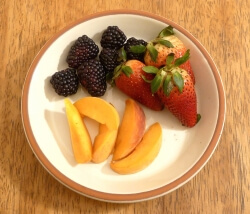 Cut up mixed fruit on a plate