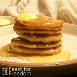 Stack of grain free and gluten free pancakes with butter and pancake syrup