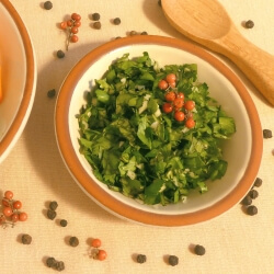 Herb sprinkle made from fresh herbs on a plate next to steamed veggies