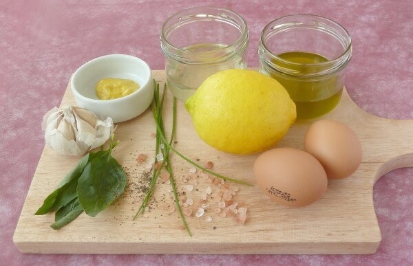 Ingredients on a wooden cutting board to make fresh mayonnaise