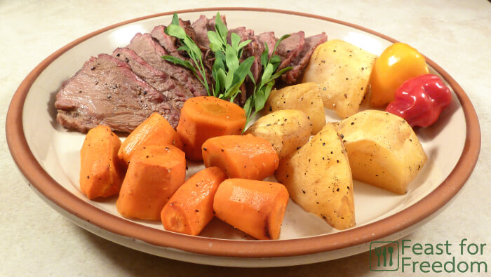 Roast beef on a plate with potatoes and carrots