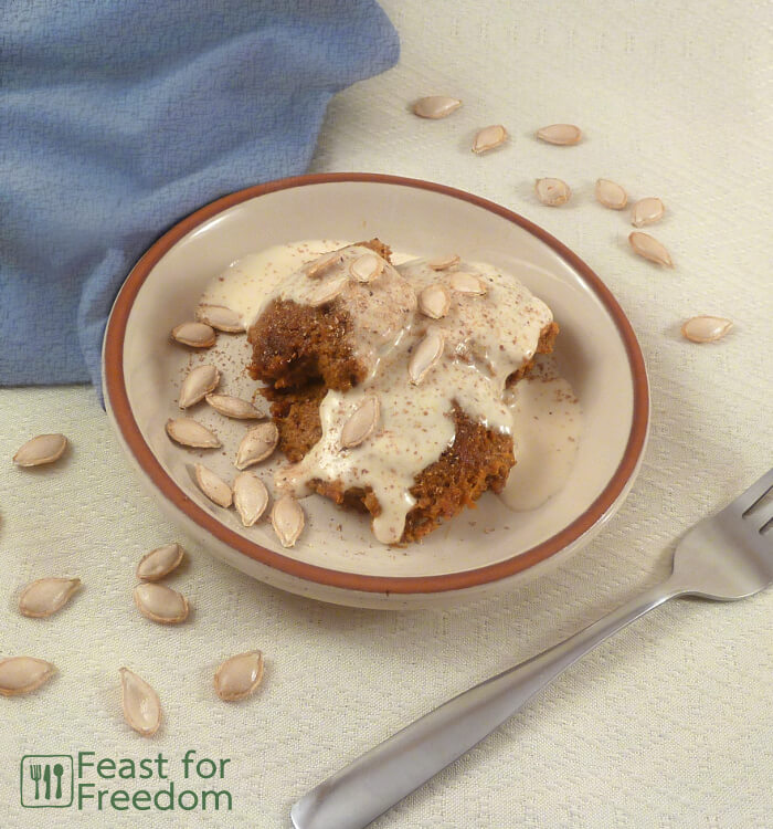 Crustless pumpkin pie drizzled with thick cream on a plate