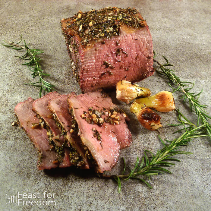 Sliced roast beef with pearl onions and rosemary sprigs