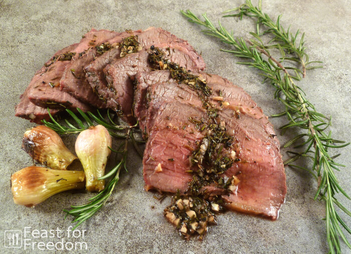 Sliced roast beef with fresh rosemary and roasted onions