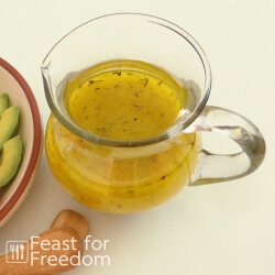 Shake and serve simple salad dressing in a glass jar next to a veggie plate