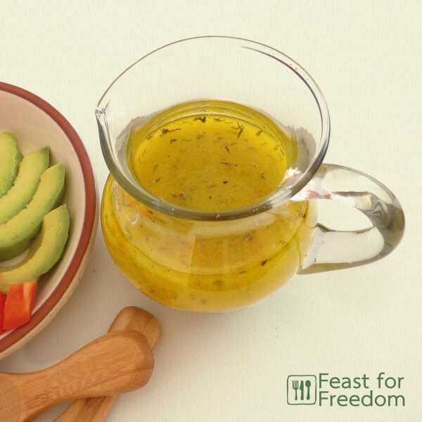 Shake and serve simple salad dressing in a glass jar next to a veggie plate